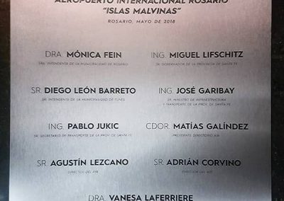 Placa conmemorativa de acero inoxidable con nombres grabados para la inauguración de obras del Aeropuerto Internacional Rosario