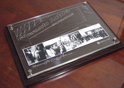 Placa recordatoria rectangular de acrílico transparente con fotografías históricas y base de madera