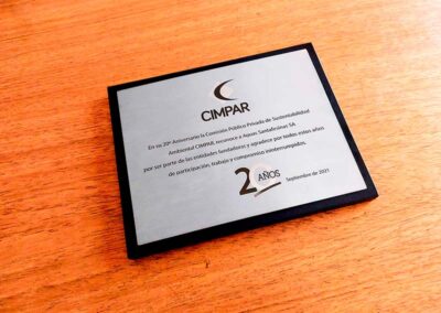 Plaqueta cuadrada de acero inoxidable por el 20 aniversario de Cimpar sobre base de madera negra