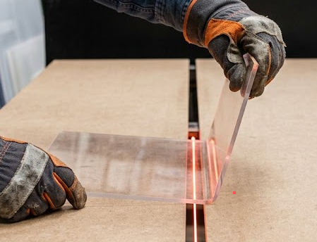 Operario de fabrica Laser House plegando acrílico cristal con calor